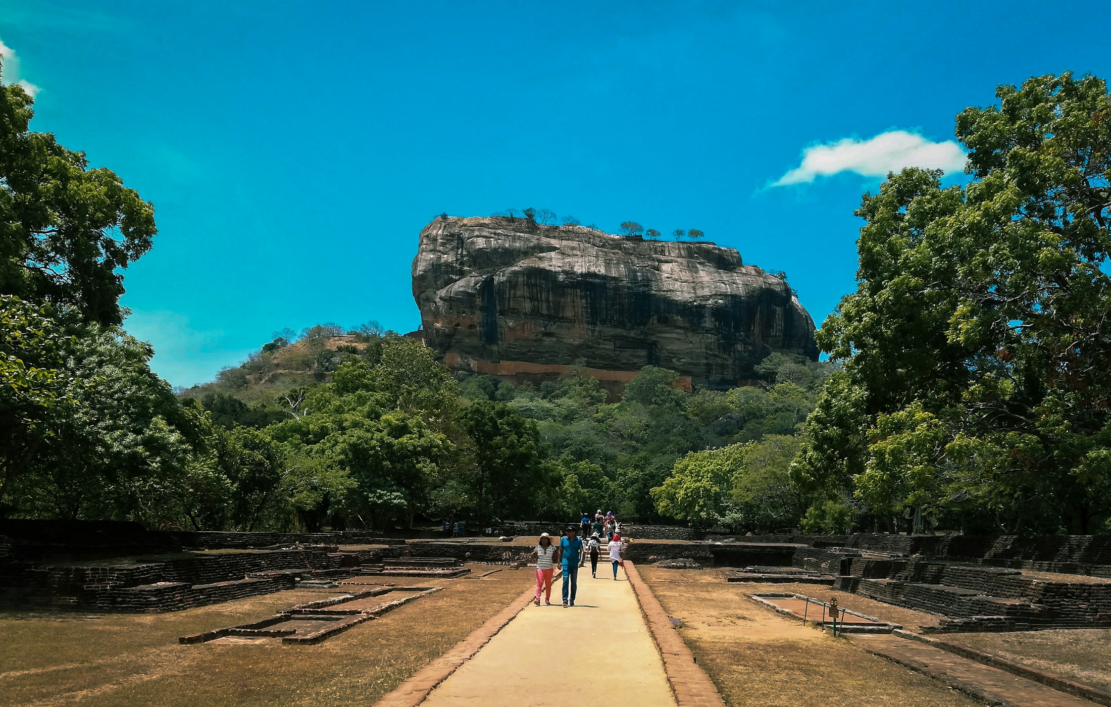 Travellers walking toward Sigiriya Rock Fortress in Sri Lanka