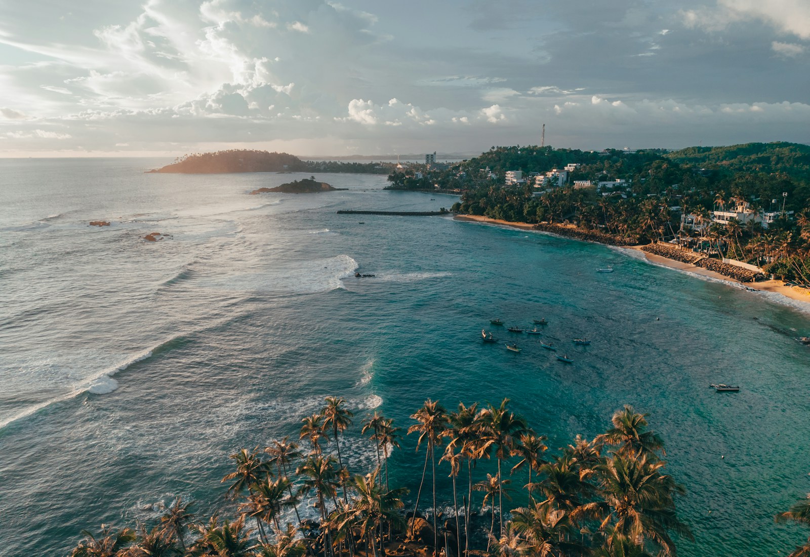 Aerial view of palm-lined Mirissa Beach at sunset